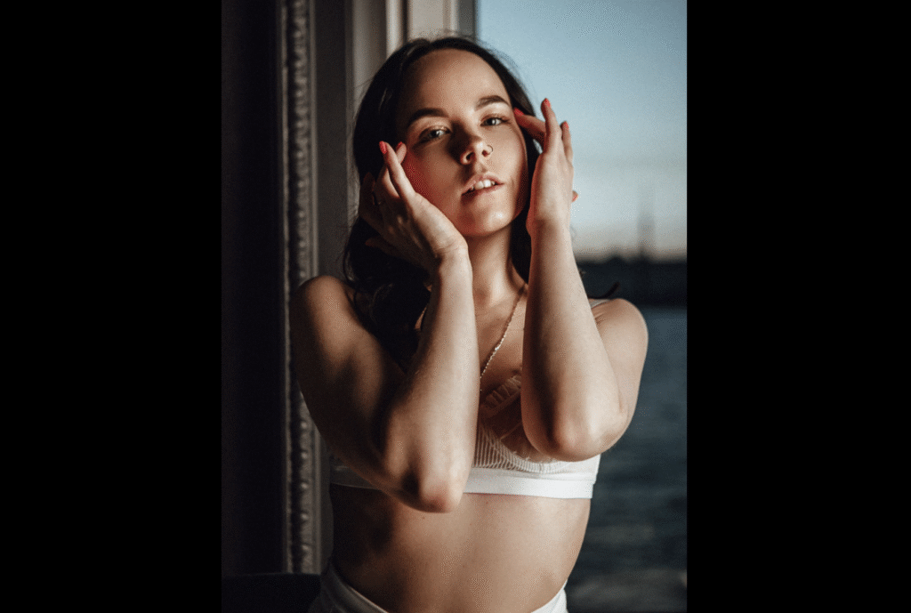 shy English girl poses in her bra in front of the sea