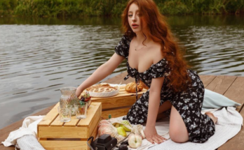 Red haired Ukrainian VR cam model posing outdoors in picnic shot.